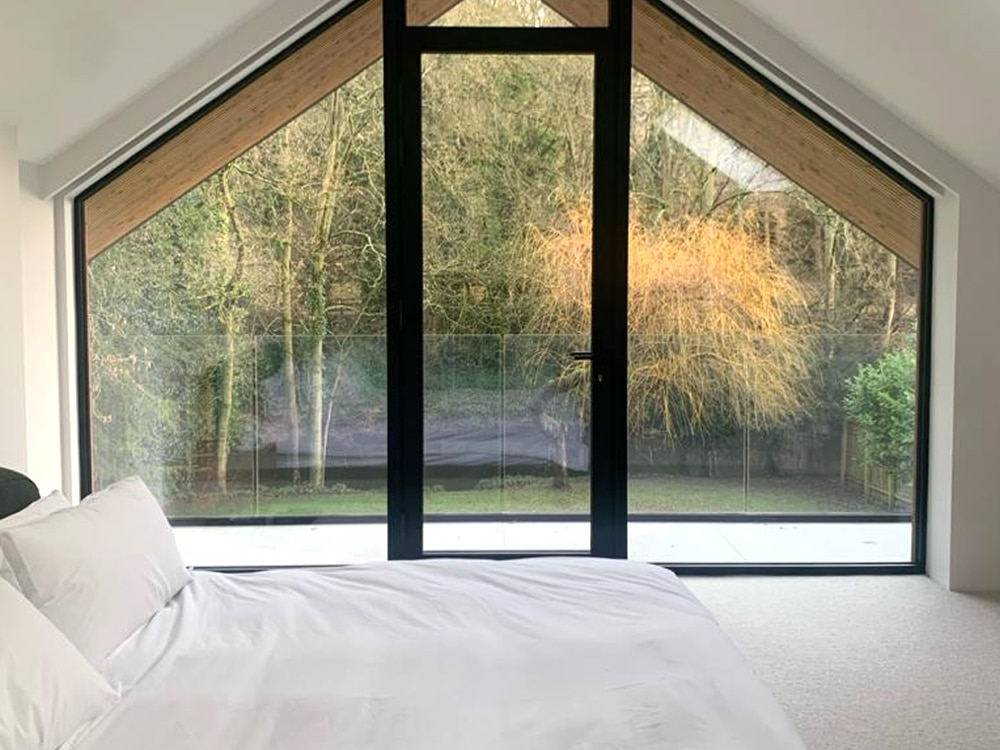 Bedroom with large aluminium window and garden view